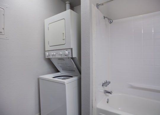 White washer and dryer in a bathroom with a shower and a sink  at Governor's Park, Fort Collins, 80525