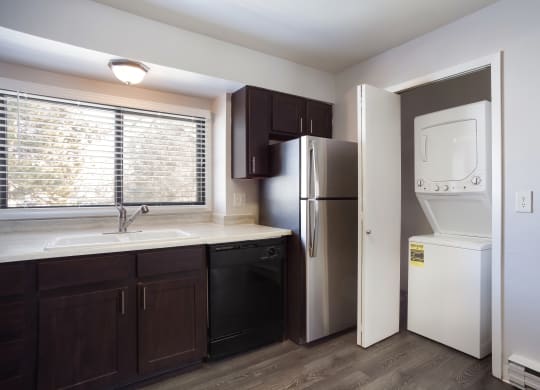 Empty kitchen with a washer and dryer in closet  at Governor's Park, Fort Collins, 80525